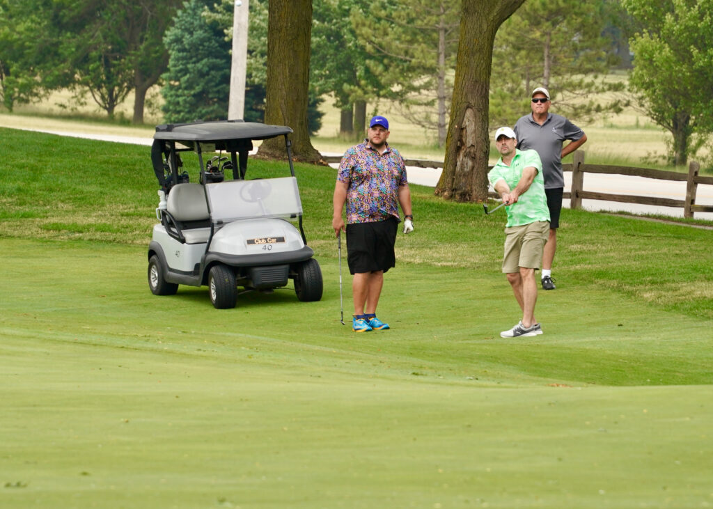 men with golf cart golfing